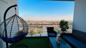 a room with a large window with a swing at Sky Heights Designer Apartments-Centaurus View in Islamabad