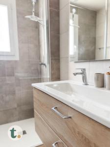 Un baño con lavabo blanco y ducha. en Tranquiloue - Escapade 14 min du Puy du Fou, en La Verrie