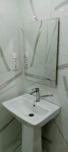 une salle de bains avec un lavabo blanc et un miroir dans l'établissement Résidence touristique marcadal by Mon rêve, à Fort-de-l'Eau