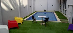 une pièce avec une piscine équipée de chaises longues et d'une table. dans l'établissement Résidence touristique marcadal by Mon rêve, à Fort-de-l'Eau 31 autres photos