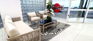 a living room with a couch and chairs on a balcony at Tenbury by the beachfront 806 in Durban