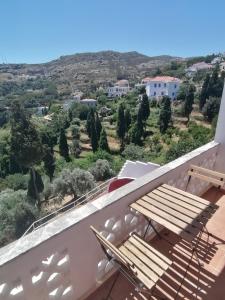 a balcony with a wooden bench and a view at Bluenigma Hotel 5 in Andros