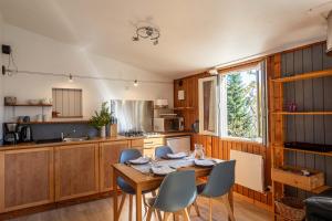 una cucina con tavolo e sedie in legno in una stanza di Le Clou a Thiézac Altre 13 foto