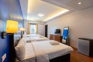 pokój hotelowy z 3 łóżkami i telewizorem z płaskim ekranem w obiekcie The Strype Hotel Tagaytay w mieście Tagaytay