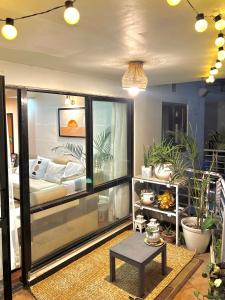 a room with a bed and a table and plants at Cozykeyz 2BHK apartment with balconies near swayambhu in Katmandu International +14 photos