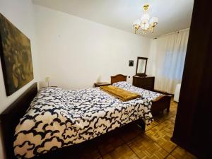 a bedroom with a bed with a black and white comforter at Bilocale Golf One Bedroom & Living Room with Sofa Bed in Rapallo