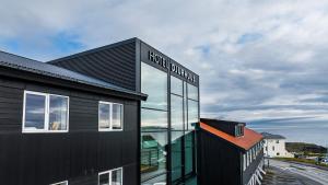 a black building with a sign on the side of it at Hotel Djurhuus in Tórshavn