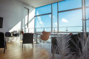 a room with chairs and a table and large windows at Hotel Djurhuus in Tórshavn
