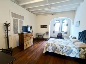 a bedroom with a bed and a dresser with a television at Casa Turística Monumental in Lima