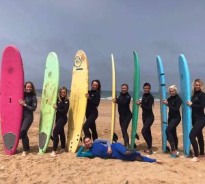 a group of women standing on the beach with surfboards at Surf & Skate in Taghazout