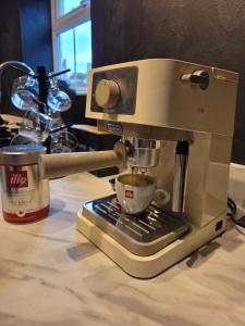 a coffee machine sitting on a counter with a cup at Villa Emma - Modern Bungalow with EV Point, Free Parking & Workspace in Northampton +15 photos