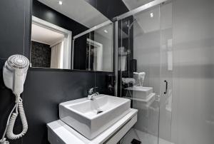 a bathroom with a sink, toilet and shower at Hotel Pilar Plaza in Zaragoza