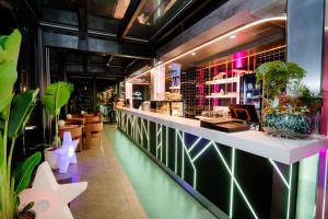 a restaurant with a bar with plants and lights at X-Digital HOTEL in Bắc Ninh