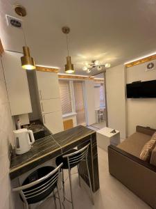 a kitchen and living room with a table and chairs at Central Park View in Chişinău