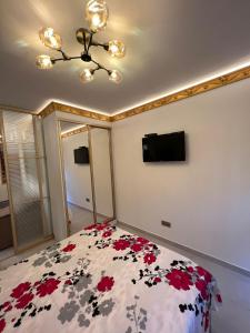 a bedroom with a bed with red flowers on it at Central Park View in Chişinău