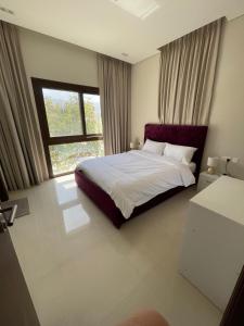 a bedroom with a large bed and a window at Sunrise Haven in As Sīfah