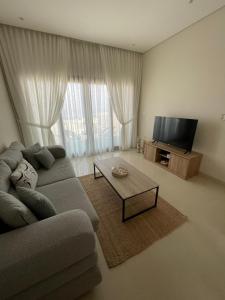 a living room with a couch and a flat screen tv at Sunrise Haven in As Sīfah