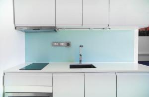 a kitchen with white cabinets and a sink at 芭提雅瞰海无边泳景泳池健身房公寓 直达海滩椰子树旁 in Pattaya South