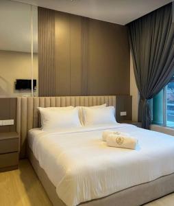 Un dormitorio con una gran cama blanca con una toalla encima. en Royal Guest House RGH, en Kota Bharu 58 fotos más