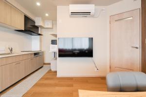 een keuken met een grote flatscreen-tv aan de muur bij Terrace Tokyo Otsuka in Tokyo