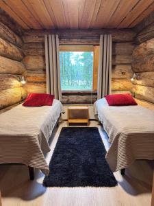 Un dormitorio con dos camas en una cabaña de madera. en Rukan Salonkilomat, en Ruka