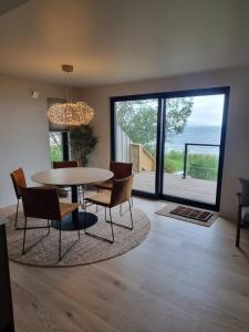 a dining room with a table and chairs and a large window at House by the fjord in Vadsø