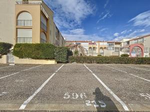 ein Parkplatz vor einem Gebäude in der Unterkunft Le Muge - Appartement Rez-de-chaussée - Piscine in Narbonne-Plage + 6 Fotos
