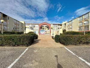 ein leerer Parkplatz vor einem Gebäude in der Unterkunft Le Muge - Appartement Rez-de-chaussée - Piscine in Narbonne-Plage