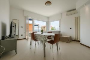 a dining room with a table and chairs and a television at WELCOME RIVIERA-Primavera 1A- Vista mare- spazioso e comodo appartamento-2 bagni-wifi-aria condizionata in ogni stanza-garage a 15 euro al giorno in Rapallo