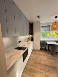 eine Küche mit weißen Schränken und einem Esstisch in der Unterkunft Premium Apartments A&S in Czernowitz + 58 Fotos