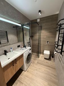 ein Badezimmer mit Waschmaschine und Waschbecken in der Unterkunft Premium Apartments A&S in Czernowitz