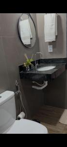Un baño con un inodoro blanco y un lavabo. en Tríade Chalé da Canastra 1, en São Roque de Minas