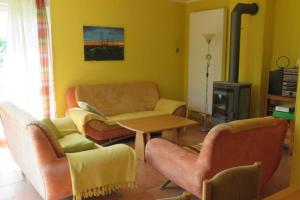 Una sala de estar con un sofá y sillas y una mesa. en Ferienhaus Retzow, en Rechlin