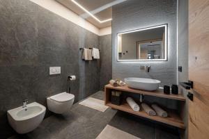 a bathroom with a sink and a toilet and a mirror at Niederhof - Urlaub auf dem Bauernhof in Brixen +23 photos