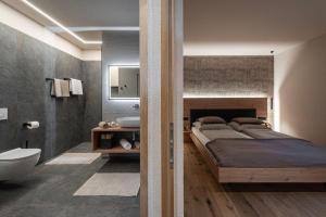 a bedroom with a large bed and a bathroom at Niederhof - Urlaub auf dem Bauernhof in Brixen