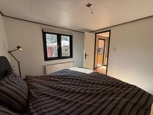 a bedroom with a bed and a window at Luxe Chalet Veluwe - Perfect Getaway in Voorthuizen +16 photos