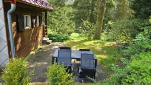 a house with a picnic table in the yard at Chata Babča in Jetřichovice