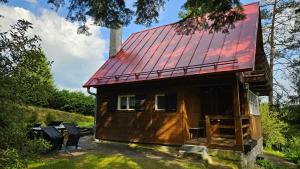 a small wooden house with a red roof at Chata Babča in Jetřichovice