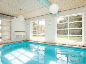 a large swimming pool in a room with windows at 10 person holiday home in Fur-By Traum in Fur