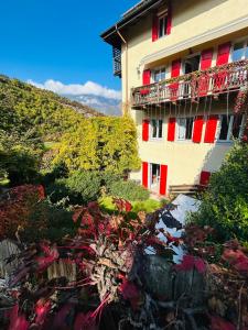 a building with red and white windows and plants at Appartamento Sopramonte in Trento