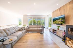 a living room with a couch and a tv at Sauna & Pool Table - Nordik Attitude in Saint-Philémon