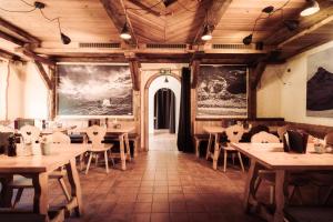 un restaurant avec des plafonds en bois, des tables et des chaises dans l'établissement Berghaus Grünsee, à Zermatt 27 autres photos