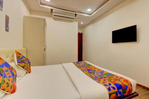 a bedroom with a bed and a tv on the wall at Via 24K Inn - Nr Manipal Hospital in Mundhwa