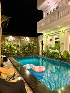 a swimming pool in a house at night at Fullhouse Hoian in Hoi An