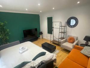 una sala de estar con una cama y un sofá en Rooms in stylish house, en Milton Keynes