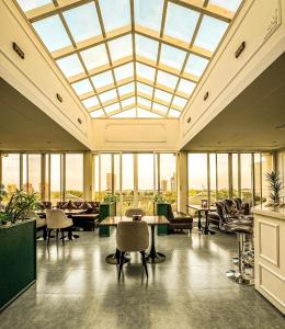 une grande pièce avec un plafond en verre avec des tables et des chaises dans l'établissement Chirani Signature Hotel, à Islamabad