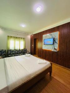 sypialnia z łóżkiem i telewizorem na ścianie w obiekcie Coolspot Cottage w mieście Utakamand