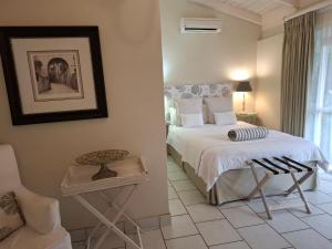 a bedroom with a bed and a chair at Avillahouse Guesthouse in Durban +24 photos