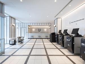a lobby with desks and chairs in a building at Brackets Hotel Osaka Hommachi in Osaka