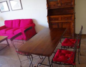 a dining room with a wooden table and pink chairs at Comodo Apartamento con Terraza y Vistas al Mar in Los Realejos